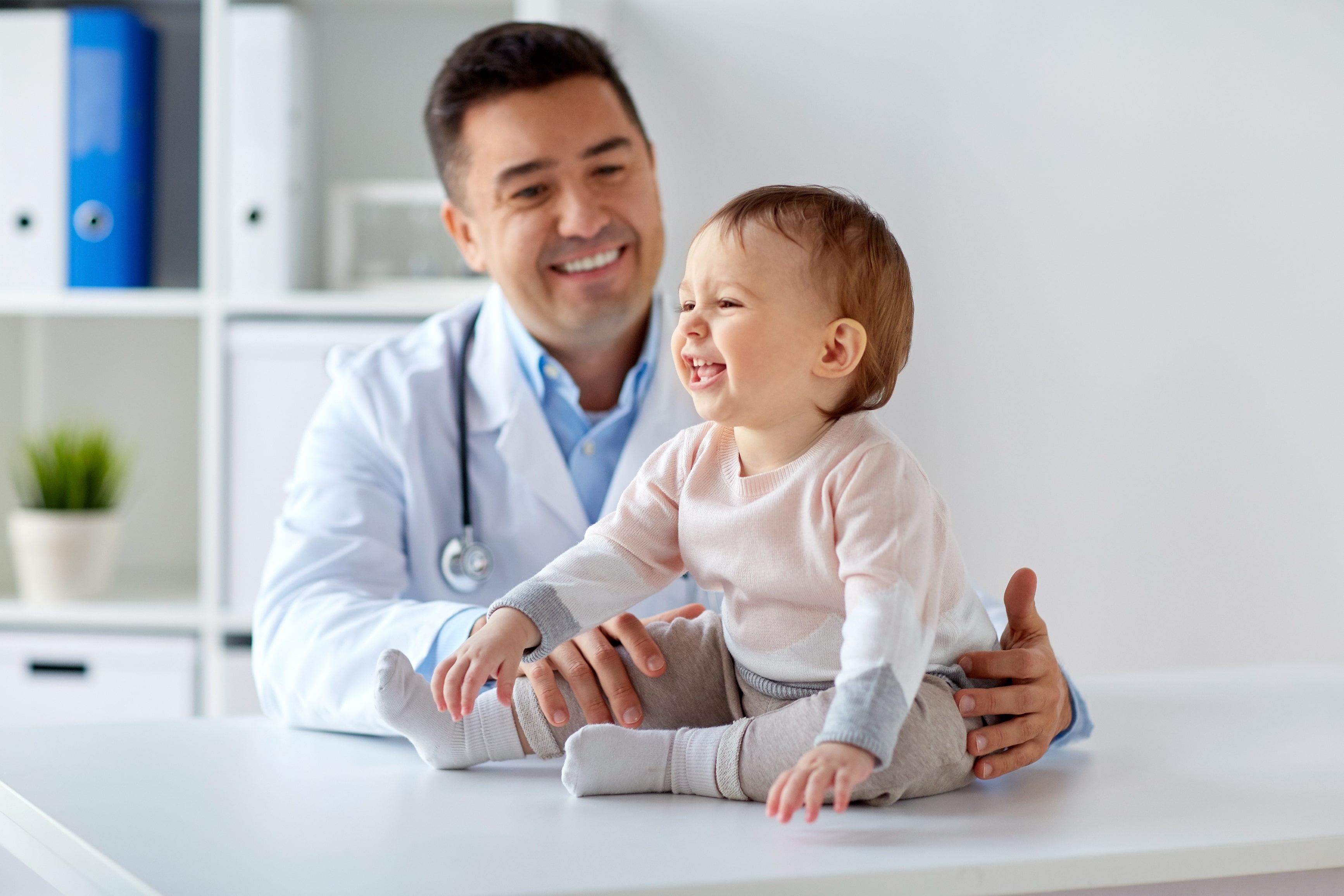 Child and her pediatrician smiling in a medical appointment.