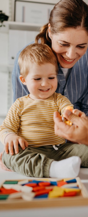 Father smiling with his daughter on his lap, leaning against his chest